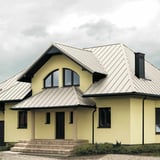 Stehfalzblech PD-510-S Flach, Reinweiß RAL 9010, auf einem Wohnhaus mit Erker und Schornstein