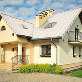 Haus mit reinweißem Stehfalzblech PD-510-S Flach Dach, Dachfenster und Schornsteine