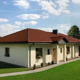 Stehfalzblech PD-510-S Mikro Ziegelrot auf einem Bungalow mit Gartenweg
