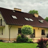 Stehfalzblech PD-510-S Mikro Schokoladenbraun auf einem Wohnhaus mit Dachfenstern