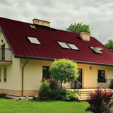 Haus mit Dach aus weinrotem Stehfalzblech PD-510-S Mikro, mit Dachfenstern
