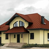 Haus mit Dach aus Stehfalzblech PD-510-S Mikro Ziegelrot, Vorderansicht mit Gaube