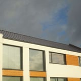 Stehfalzblech PD-510-S Mikro Graualuminium auf einem modernen Flachdach mit grossen Fenstern