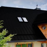 Nahaufnahme des Daches aus Stehfalzblech PD-510-S Tiefschwarz, 0,50 mm Stahl, mit Dachfenstern