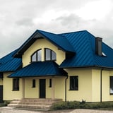 Haus mit Stehfalzblech PD-510-S Dach in Enzianblau (RAL 5010) und Gauben