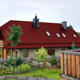 Stehfalzblech PD-510-S Kirschrot auf einem Wohnhaus mit mehreren Dachfenstern, Verlegung