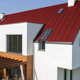 Stehfalzblech PD-510-S Kirschrot auf einem weissen Haus mit Dachfenstern, Verlegung