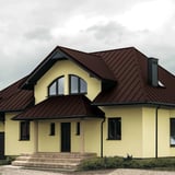 Stehfalzblech PD-510-S schokoladenbraun auf einem Wohnhaus mit gelber Fassade