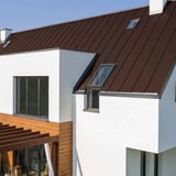 Stehfalzblech PD-510-S schokoladenbraun auf einem weissen Haus mit Holzpergola