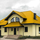 Stehfalzblech PD-510-S Rapsgelb auf einem Wohnhaus mit Giebel und Schornstein