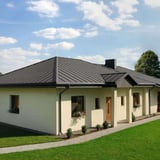Stehfalzblech PD-510-S Graualuminium auf einem Bungalow-Dach mit Schornstein und Vorgarten