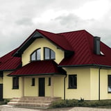 Stehfalzblech PD-510-S weinrot auf einem Wohnhaus mit Gauben und Schornstein