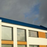 Modernes Gebaeude mit Dach aus Stehfalzblech PD-510-S Trapez Enzianblau RAL 5010