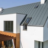 Stehfalzblech PD-510-S Trapez Fehgrau auf einem weissen Haus mit Dachfenstern