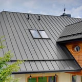 Stehfalzblech PD-510-S Trapez in Weißaluminium RAL 9006 auf einem Dach mit Dachfenstern