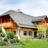Stehfalzblech PD-510-S Trapez in Weißaluminium RAL 9006 auf einem Haus mit Holzelementen
