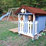 Trapezblech 20/1100 rotbraun auf dem Dach eines blauen Kinderspielhauses, Anwendungsbeispiel