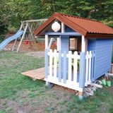 Trapezblech 20/1100 kupferbraun auf dem Dach eines blauen Kinderspielhauses mit Rutsche
