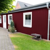 Anbau mit weinrotem Trapezblech 20/1100 als Wandverkleidung, Fenster und Tür