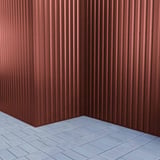 Trapezblech 20/1100 Rotbraun als Eckverkleidung einer Wand mit Pflastersteinen
