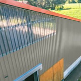 Trapezblech 20/1100 Aluminium Graualuminium an einer Hallenwand mit Lichtplatten