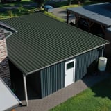 Trapezblech 35/207 Chromoxidgrün auf einem Carport mit angrenzender Garage und Regenwassertonne