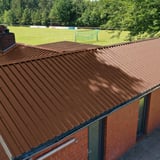 Trapezblech 35/207 Nussbraun als Dach auf einem Sportvereinsgebaeude mit Schornstein