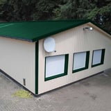 Trapezblech 35/207 Dach Moosgrün auf einem Lagergebäude mit hellen Wänden