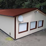 Trapezblech 35/207 rotbraun auf einem Lagerhallendach, Ansicht von der Seite mit Fassade