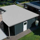 Trapezblech 35/207 Grauweiß als Dach auf einer Garage mit dunkler Holzfassade