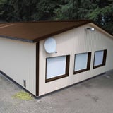 Trapezblech 35/207, sepiabraun, auf einem Gebaeude mit hellen Fassadenplatten verbaut