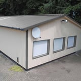 Trapezblech 35/207, Weißaluminium, auf einem beigefarbenen Gebäude mit Fenstern, Verlegung
