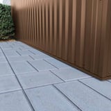 Detailansicht der Wandverkleidung aus Trapezblech 35/207 Sepiabraun RAL 8014 am Gebaeudesockel