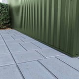 Detailansicht der unteren Kante von vertikal verlegtem Trapezblech 35/207 in Chromoxidgrün auf Pflaster