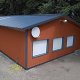 Halle mit Wandverkleidung aus kupferbraunem Trapezblech 35/207 und dunklem Dach