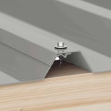 Verzinkte Schraube Graualuminium RAL 9007 befestigt ein Kantteil auf einem Trapezblech