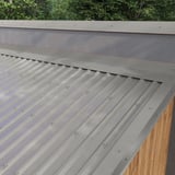 Verlegung des Wandanschlusses aus Graualuminium RAL 9007 auf einem Dach mit Trapezblechen
