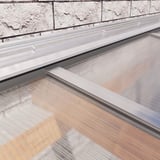 Wandanschlussprofil aus blankem Aluminium auf einer Mauer, ueber Lichtplatten montiert