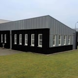 Gewerbegebaeude mit Wellblech 18/1064 Tiefschwarz (RAL 9005) als Fassadenverkleidung