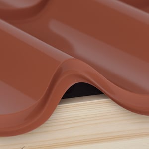 Profilfüller aus schwarzem Schaumstoff unter einem roten Dachblech auf Holzlatten, Detailansicht