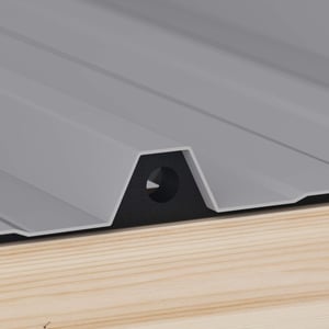 Profilfüller aus schwarzem Schaumstoff unter grauem Trapezblech auf Holzkonstruktion, Detailansicht