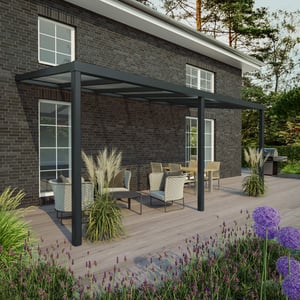 Terrassenueberdachung RAL 7016 an Hausfassade, mit Sitzgruppe auf Holzterrasse