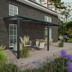 Terrassenüberdachung RAL 7016 mit 8,00 mm Glasdach an einem Haus, Gesamtansicht mit Gartenmöbeln