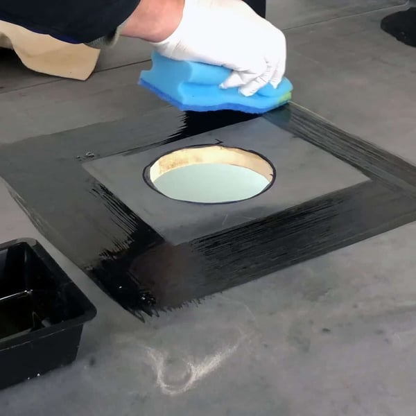 EPDM Aktivierung wird mit blauem Schwamm um einen runden Dachausschnitt aufgetragen
