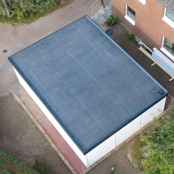 Verlegte schwarze EPDM Dachfolie auf einem Flachdach eines Garagenanbaus, Draufsicht