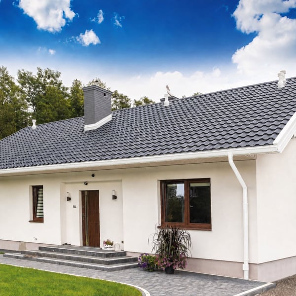 Hausfassade mit Reinweiß (RAL 9010) Fallrohrbogen und Dachrinne von Niagara