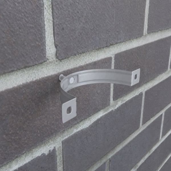 Fallrohrschelle aus Stahl in Graualuminium (RAL 9007) an einer Ziegelwand montiert