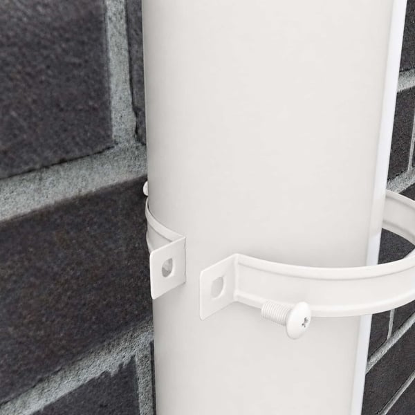 Detailaufnahme der reinweißen Fallrohrschelle mit Schraube, die ein Fallrohr an der Wand fixiert