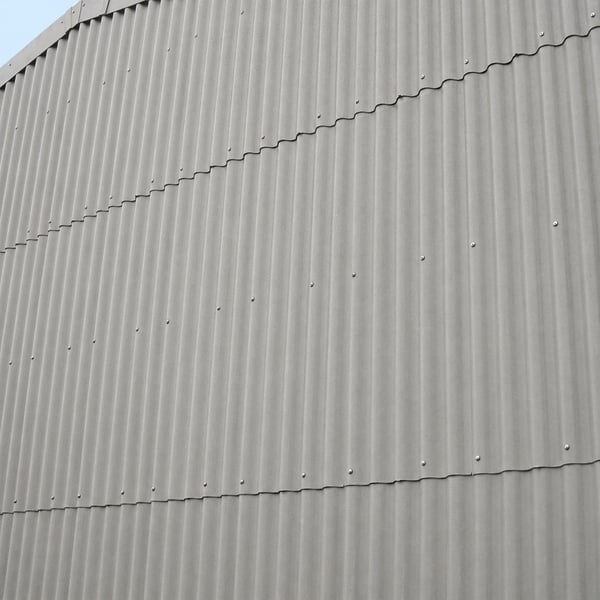Fassade verkleidet mit naturgrauen Faserzement Wellplatten Europa Profil 5, vertikal montiert