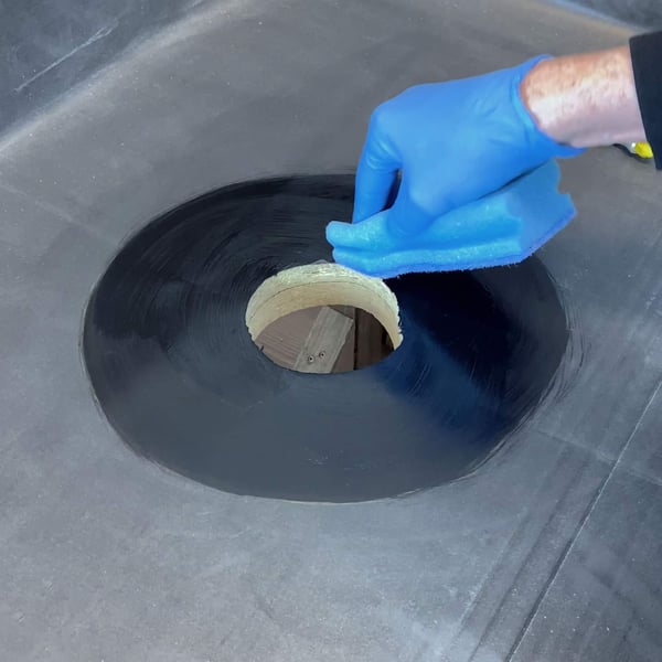 Garantie-Gully aus schwarzem EPDM, Hand mit blauem Handschuh reinigt Oberflaeche